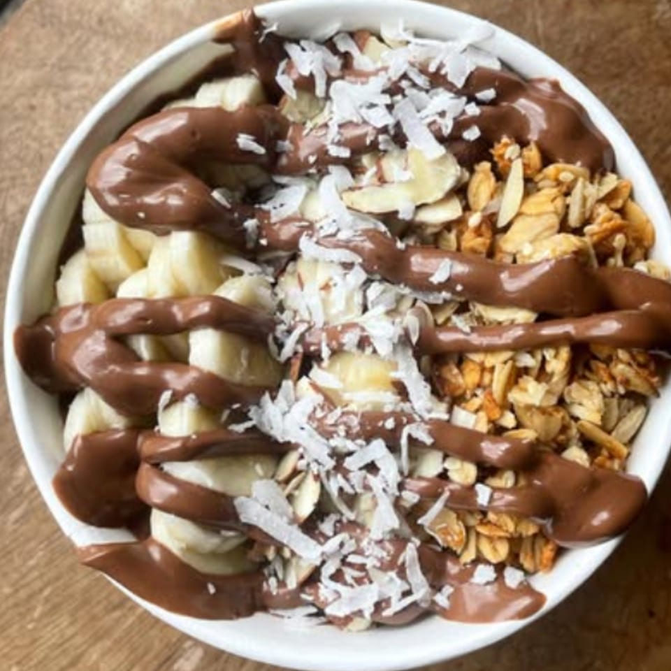 A chocolate acai bowl with bananas, granola, almonds, and shredded coconut from Menehune Coffee Company.