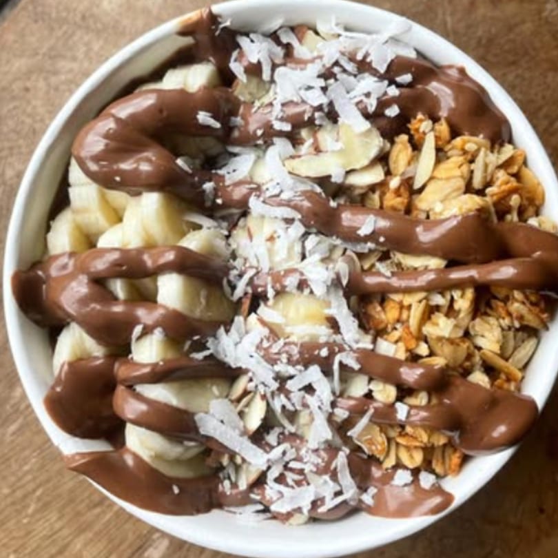 A chocolate acai bowl with bananas, granola, almonds, and shredded coconut from Menehune Coffee Company.