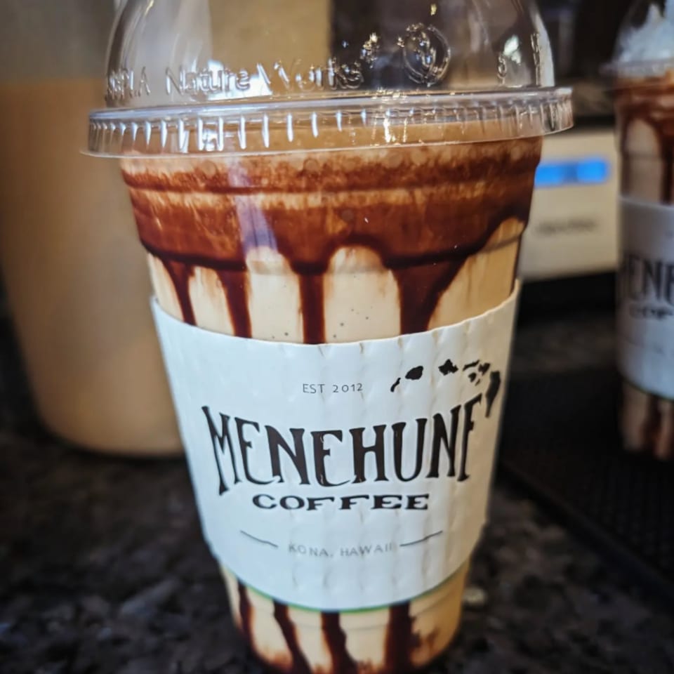 A Menehune Coffee Company iced coffee drink with chocolate syrup drizzled inside the cup.