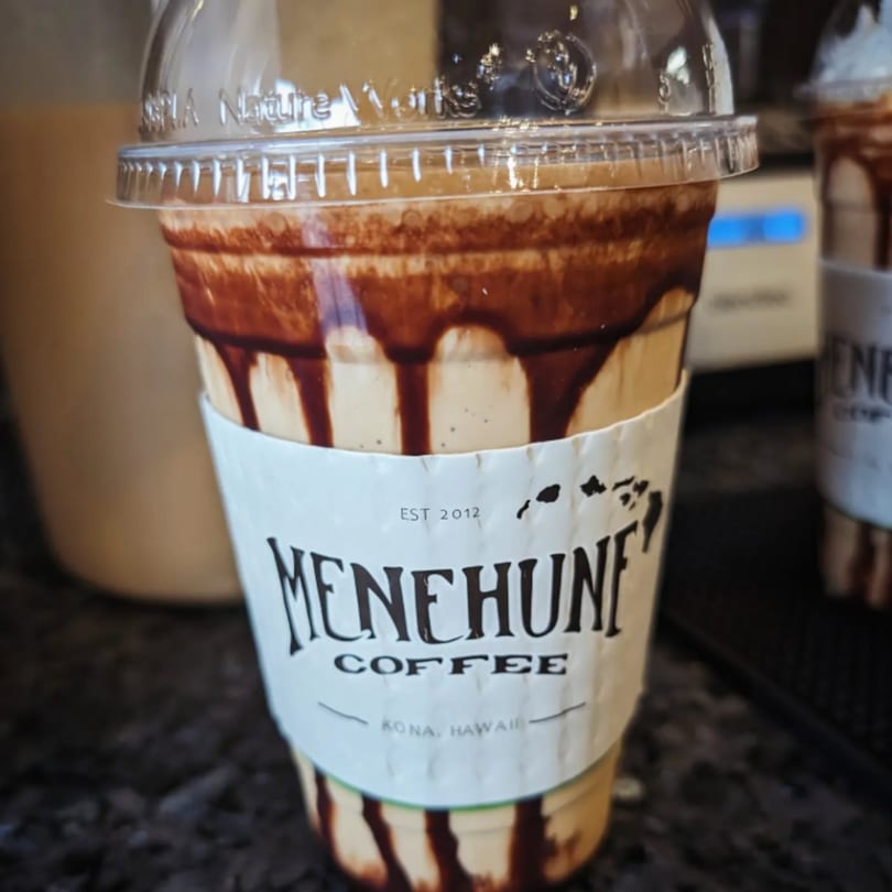 A Menehune Coffee Company iced coffee drink with chocolate syrup drizzled inside the cup.
